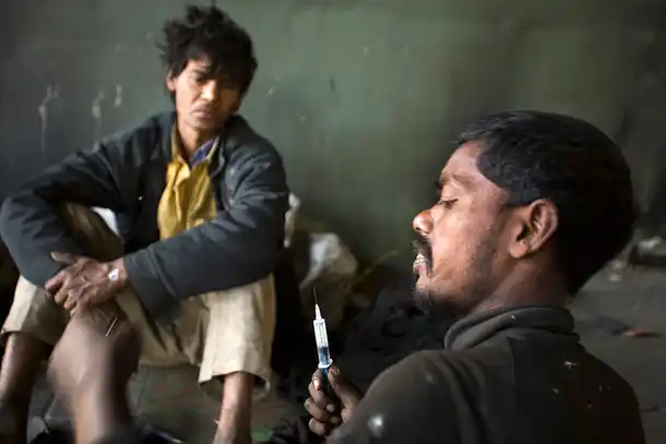 India - Homelessness New Delhi - Homeless addicts prepare and inject heroin